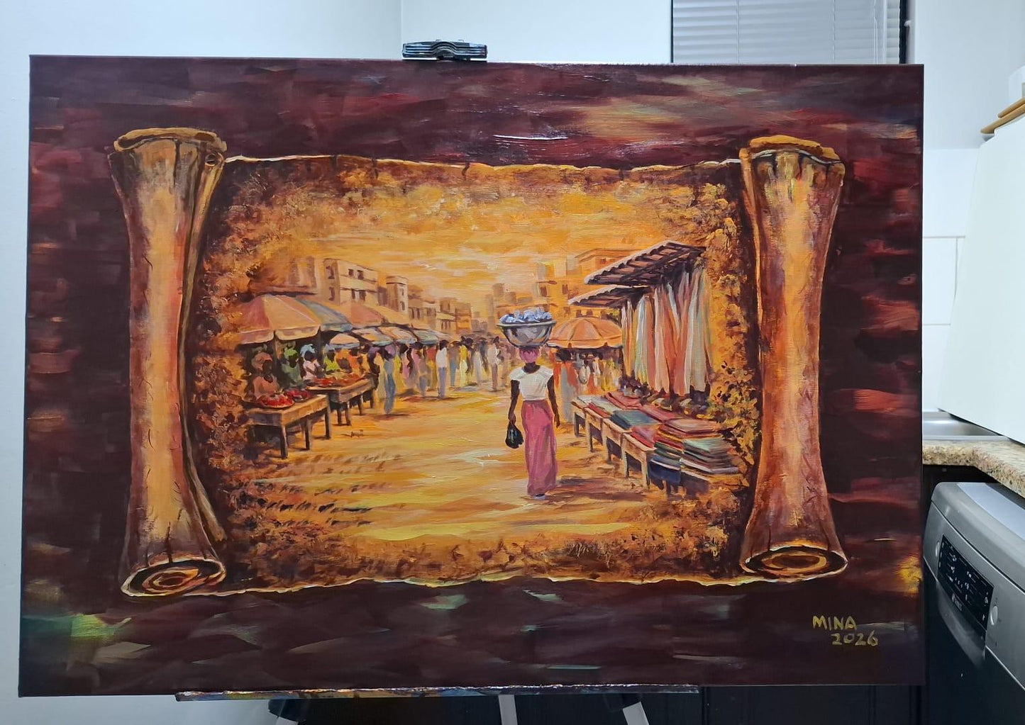 Acrylic painting by MINA titled Makola Market Women 2, showing a Ghanaian market scene within an aged scroll format, with women, market stalls, warm golden tones, and a central female figure carrying goods through Makola Market.