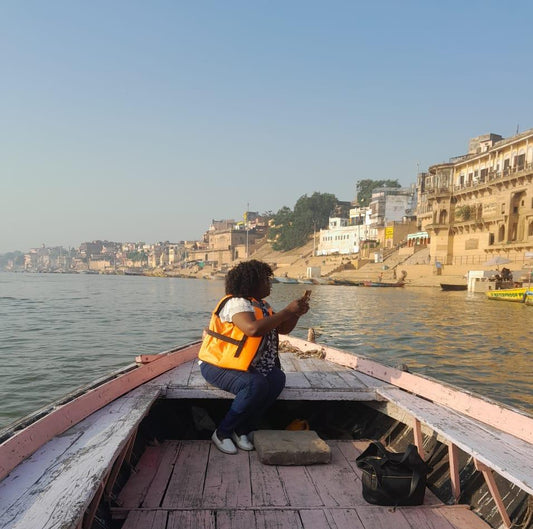 "During her four years living in India, MINA made numerous visits to Varanasi. This photograph captures the artist travelling by boat on the River Ganges while documenting the historic ghats that later inspired works within the Varanasi Collection."
